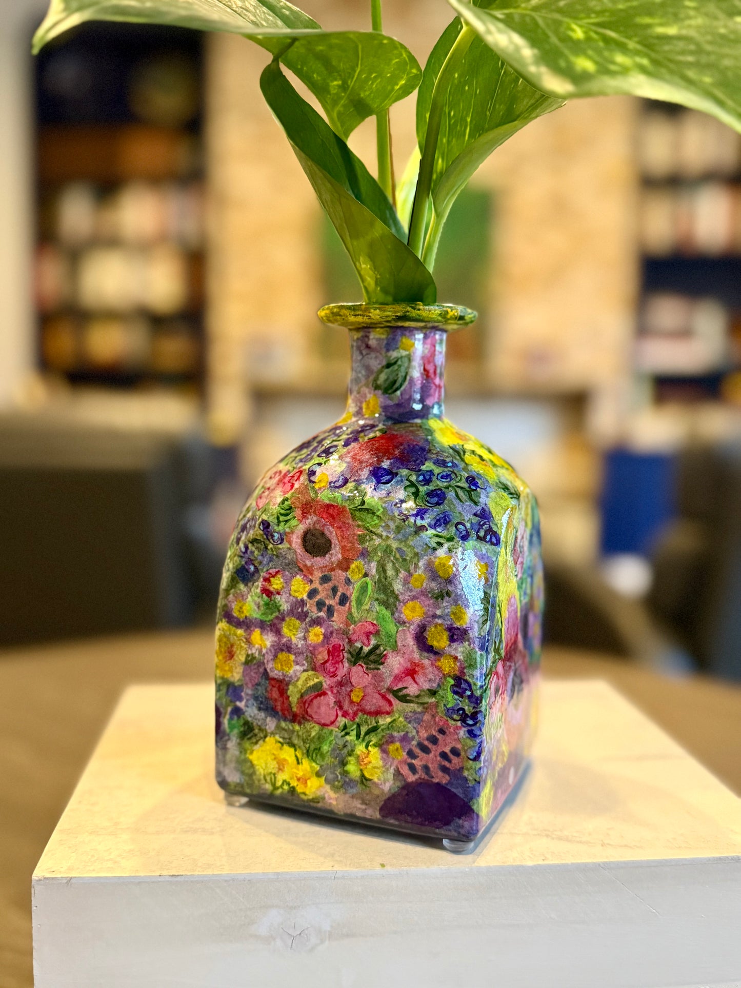 Maximalist style repurposed tequila bottle flower vase