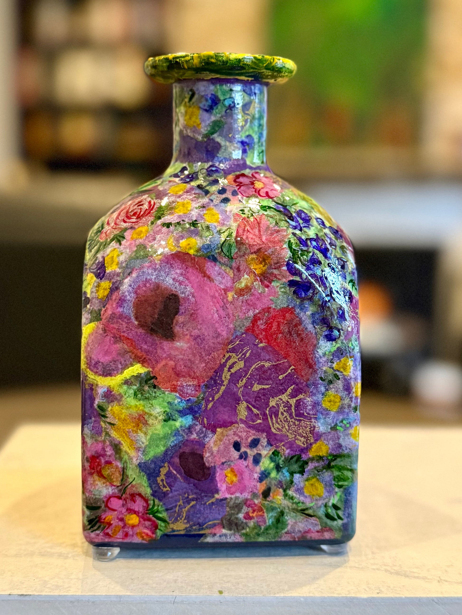Colorful floral-patterned repurposed tequila bottle flower vase